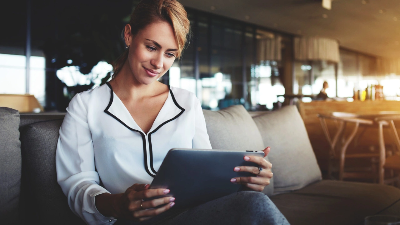 Photo of a young woman learning on an iPad, illustrating the Tutoreca blog article about brand-aligned training in hospitality.